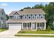 Charming two-story home featuring blue siding, a welcoming front porch, and a convenient attached two-car garage at 2720 Spotted Coral Ct, Apex, NC 27502