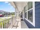 Covered front porch featuring white railing and a view of the neighborhood street at 2720 Spotted Coral Ct, Apex, NC 27502