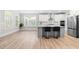 Well-lit kitchen and breakfast area with stainless appliances, a gray island, and large windows at 2720 Spotted Coral Ct, Apex, NC 27502