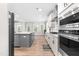 Modern kitchen with gray island, stainless appliances, double oven, light hardwood floors and ample natural light at 2720 Spotted Coral Ct, Apex, NC 27502