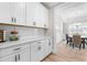 Bright kitchen with white cabinets, quartz countertops and adjacent dining area with hardwood floors at 2720 Spotted Coral Ct, Apex, NC 27502