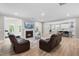 Open-concept living area featuring a fireplace, modern sofas, and wood floors at 2720 Spotted Coral Ct, Apex, NC 27502