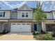 Charming two-story townhome featuring brick accents, a two-car garage, and a welcoming blue front door at 273 Broomside Ave, Raleigh, NC 27603