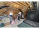 Unfinished attic space with exposed wooden beams and a window, offering potential for customization at 3057 Eden Harbor Ct, Raleigh, NC 27613