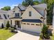 Two-story home with a two-car garage, complemented by green lawns and mature trees at 3057 Eden Harbor Ct, Raleigh, NC 27613