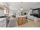 Modern kitchen with an island overlooking a living room with fireplace and backyard access at 3057 Eden Harbor Ct, Raleigh, NC 27613