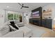 Bright living room features an electric fireplace, a ceiling fan, and a large sectional couch with neutral tones at 3057 Eden Harbor Ct, Raleigh, NC 27613