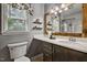Stylish bathroom with wood-framed mirror, marble countertop, and decorative fixtures at 311 Westbrook Dr, Carrboro, NC 27510
