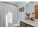 Bathroom featuring a single sink vanity with light blue walls and decorative shelf and bronze fixtures at 311 Westbrook Dr, Carrboro, NC 27510