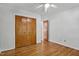 Bright bedroom with hardwood floors, closet, ceiling fan and a door leading into another room at 311 Westbrook Dr, Carrboro, NC 27510