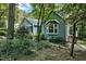 Charming light blue home featuring a beautiful bay window and lush, mature landscaping surrounding the property at 311 Westbrook Dr, Carrboro, NC 27510