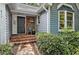 Inviting front porch with brick steps, and cozy seating, offering a welcoming entrance to the home at 311 Westbrook Dr, Carrboro, NC 27510