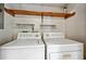 Well-equipped laundry area with washer and dryer units and storage shelves at 311 Westbrook Dr, Carrboro, NC 27510