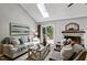 Bright living room with a vaulted ceiling, skylight, fireplace, and sliding doors to outdoor deck at 311 Westbrook Dr, Carrboro, NC 27510