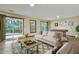 Staged living room with a comfy sofa, foosball table, a patio door, and large windows at 311 Westbrook Dr, Carrboro, NC 27510