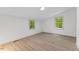 Bright bedroom with wood-look flooring and windows offering scenic views at 3218 Seven Springs Rd, Hillsborough, NC 27278