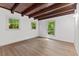 Bedroom with wood beam ceiling, hardwood floors and two windows overlooking outside scenery at 3218 Seven Springs Rd, Hillsborough, NC 27278