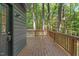 View of a deck with wood-slat flooring and wooden railings overlooking the surrounding forest at 3218 Seven Springs Rd, Hillsborough, NC 27278