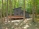 Unique exterior of a modern home featuring a large deck and surrounded by lush trees at 3218 Seven Springs Rd, Hillsborough, NC 27278
