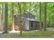 Exterior view of a two-story home with gray siding, black trim and a spacious deck in a wooded setting at 3218 Seven Springs Rd, Hillsborough, NC 27278