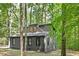 A contemporary home featuring a gray exterior with black trim, nestled in a natural, wooded setting at 3218 Seven Springs Rd, Hillsborough, NC 27278