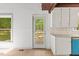 View of a kitchen with white cabinets and an adjacent doorway that leads to the deck outside at 3218 Seven Springs Rd, Hillsborough, NC 27278
