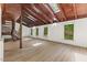 Bright living room with wood floors, exposed beam ceiling, and multiple windows offering serene views at 3218 Seven Springs Rd, Hillsborough, NC 27278