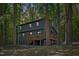 Rear exterior showing a large wooden deck perfect for outdoor entertaining surrounded by tall trees at 3218 Seven Springs Rd, Hillsborough, NC 27278