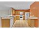 Bright kitchen with tile flooring, wooden cabinets, and modern white appliances at 3352 Tarleton W, Durham, NC 27713