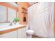 Bathroom with an orange accent wall, white cabinets, and a palm print shower curtain at 346 Summerwalk Cir, Chapel Hill, NC 27517