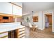 Open floor plan with white kitchen leading to dining area with wood accents and table at 346 Summerwalk Cir, Chapel Hill, NC 27517