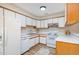 A well-lit kitchen featuring white cabinets, laminate flooring, and essential appliances at 346 Summerwalk Cir, Chapel Hill, NC 27517