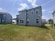 The large grassy backyard features gray siding and complementing white window trim at 3509 Bailey Lake Dr, Fuquay Varina, NC 27526