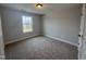 A carpeted bedroom featuring natural light through the window and neutral walls at 3509 Bailey Lake Dr, Fuquay Varina, NC 27526