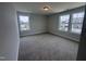 Well-lit bedroom featuring plush carpets and multiple windows overlooking the neighborhood at 3509 Bailey Lake Dr, Fuquay Varina, NC 27526