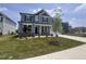 Charming two-story home with gray siding, stone accents, lush green lawn, and inviting covered front porch at 3509 Bailey Lake Dr, Fuquay Varina, NC 27526
