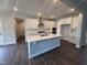 Modern kitchen with white cabinets, stainless steel appliances, quartz countertops and a large center island at 3509 Bailey Lake Dr, Fuquay Varina, NC 27526
