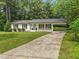Charming brick home with a well-manicured lawn, rocking chair front porch, and covered parking at 404 Troy Pl, Raleigh, NC 27609