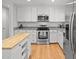 Modern white kitchen with stainless steel appliances, granite countertops, and an island at 404 Troy Pl, Raleigh, NC 27609