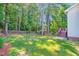 Well-maintained backyard featuring a lush green lawn, mature trees, and a charming fence at 5107 Granbury Dr, Durham, NC 27713