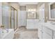 Well-lit bathroom features double sinks, a soaking tub, and a shower stall, offering comfort and convenience at 5107 Granbury Dr, Durham, NC 27713