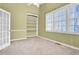 Bright bedroom with built-in shelving, large window, and plush carpet flooring at 5107 Granbury Dr, Durham, NC 27713