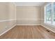 Neutral bedroom features hardwood floors, large window and white molding at 5107 Granbury Dr, Durham, NC 27713