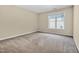 A bedroom with neutral walls, carpet, and a large window providing ample natural light at 5107 Granbury Dr, Durham, NC 27713