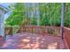Large wooden deck with railing offers great views of the lush backyard and mature trees at 5107 Granbury Dr, Durham, NC 27713