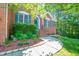 Beautiful brick home entrance with lush green landscaping and brick steps at 5107 Granbury Dr, Durham, NC 27713