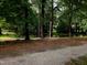 This backyard features a green lawn, large trees, and pond at 5805 Mapleridge Rd, Raleigh, NC 27609