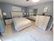 This bedroom features light-colored furniture, a ceiling fan and a large dresser with mirror at 5805 Mapleridge Rd, Raleigh, NC 27609