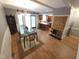 Open dining room and kitchen with exposed wood beams and a stone fireplace at 5805 Mapleridge Rd, Raleigh, NC 27609
