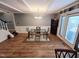 Bright dining area featuring hardwood floors, elegant light fixtures, and a glass table at 5805 Mapleridge Rd, Raleigh, NC 27609